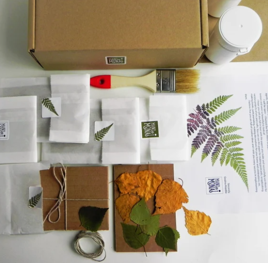 Handmade botanical paper craft kit with pressed leaves, kraft packaging, paintbrush, and natural jute twine.
