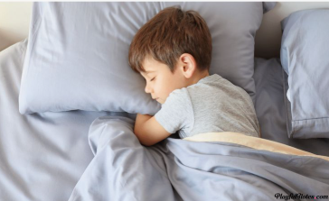 "A young boy sleeping peacefully in bed, highlighting sleep as an essential pillar of health and recovery within the 5 pillars of wellness."