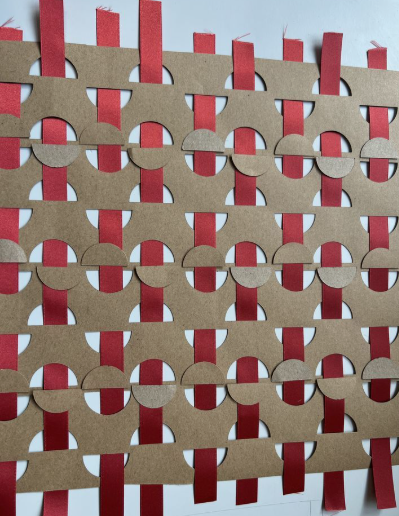 An intricate geometric pattern showcasing easy paper crafts with brown cardstock woven with vertical red ribbon strips.
