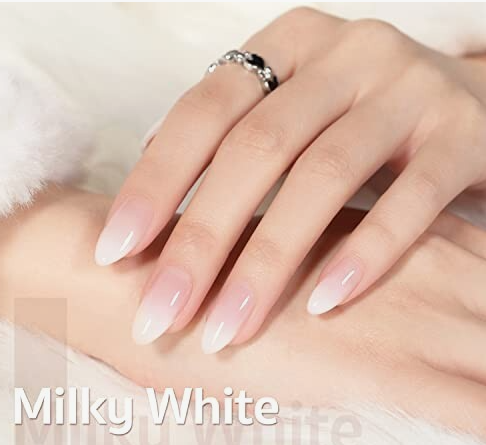 What nail colour is trending now showcased as a milky white and soft pink gradient design on almond-shaped nails with a silver ring.