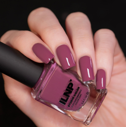 What nail colour is trending now featured as a glossy mauve-pink creme finish on square nails while holding an ILNP Studio Color nail polish bottle.