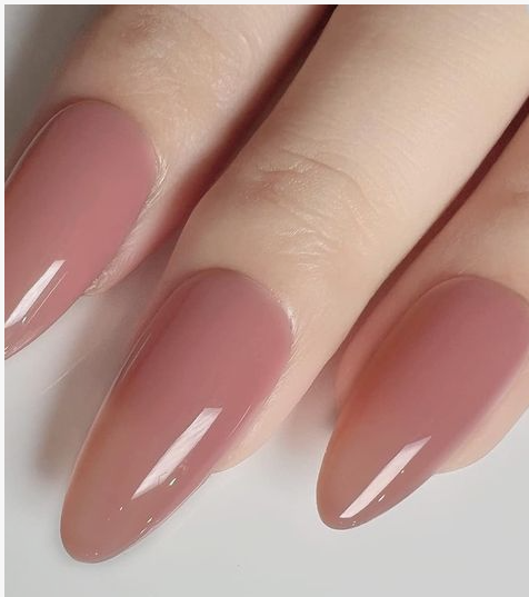 What nail colour is trending now presented as a glossy, sheer dusty rose or mauve shade on elegant almond-shaped nails.