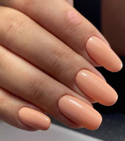 What nail colour is trending now presented as a glossy, smooth peach or nude creme shade on neat oval-shaped nails.