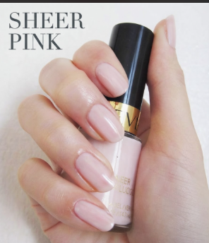 A close-up of a hand with perfectly manicured sheer pink nails, holding a bottle of matching polish, perfect for minimalist nail art inspiration on Humor Craze.