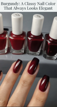 A close-up of a hand with a flawless glossy burgundy nail color manicure, featuring a rich deep red gradient, with a row of matching nail polish bottles in the background, perfect for elegant beauty inspiration on Humor Craze.
