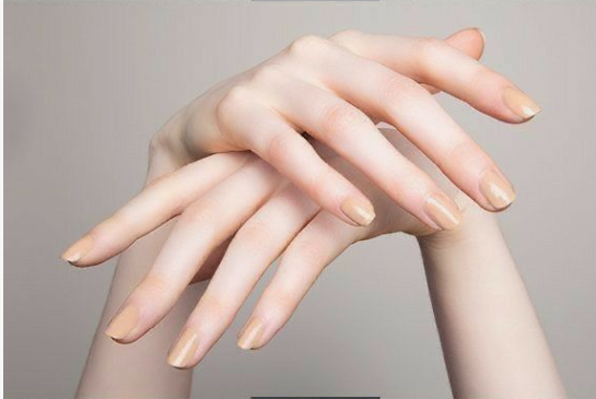 wo pale hands showcasing cool-toned nude nail polish that makes the skin look washed out, highlighting an example of nail colors that age your hands.