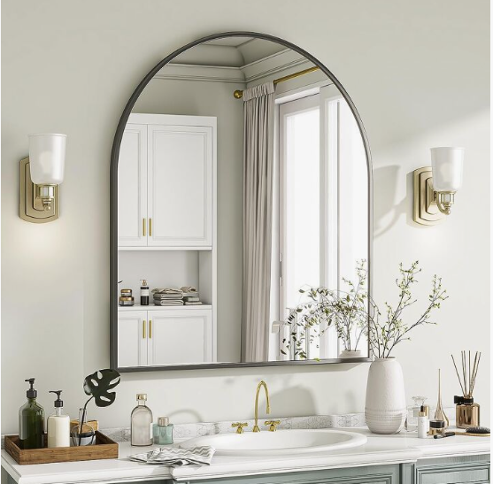 What Home Decor Items Are Trending in 2026? 15 Ideas to Refresh Your Home what home decor items are trending in 2026 highlighting an arched wall mirror over a bathroom vanity with brass fixtures and minimalist decor