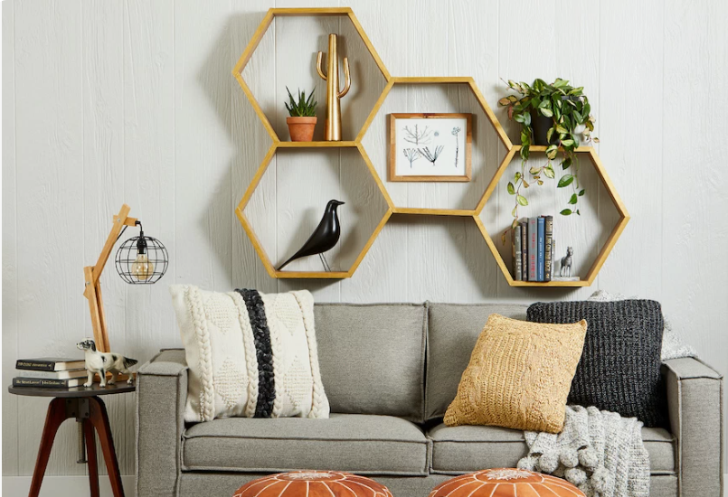 What Home Decor Items Are Trending in 2026? 15 Ideas to Refresh Your Home what home decor items are trending in 2026 highlighting honeycomb hexagonal wall shelves mounted above a grey sofa styled with textured pillows and plants