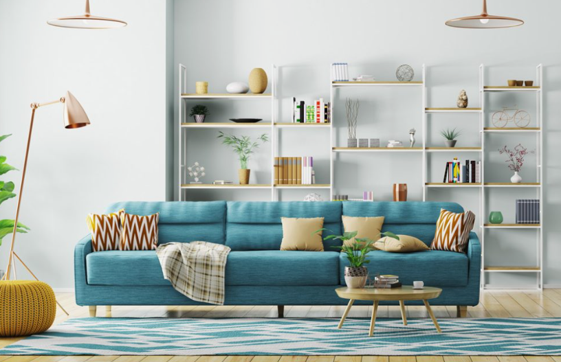 What Home Decor Items Are Trending in 2026? 15 Ideas to Refresh Your Home what home decor items are trending in 2026 highlighting a vibrant living room featuring a bright blue sofa, geometric pattern rug, open white shelving units, and modern copper lighting