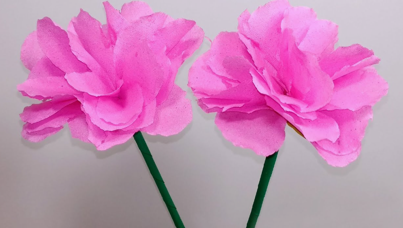 15 Easy DIY Paper Flowers for Kids: Fun Crafts for Toddlers, Preschoolers & Older Children Two fluffy pink tissue paper flowers on green stems, designed as easy paper flowers for kids.