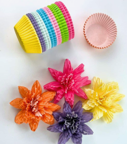 15 Easy DIY Paper Flowers for Kids: Fun Crafts for Toddlers, Preschoolers & Older Children Colorful cupcake liners stacked next to handmade flower crafts made in orange, pink, purple, and yellow, perfect for easy paper flowers for kids.