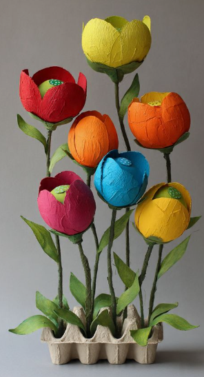 15 Easy DIY Paper Flowers for Kids: Fun Crafts for Toddlers, Preschoolers & Older Children A bouquet of vibrant, painted egg carton flowers in red, yellow, orange, pink, and blue, mounted on green stems with leaves and arranged in a small egg carton base, presented as easy paper flowers for kids.