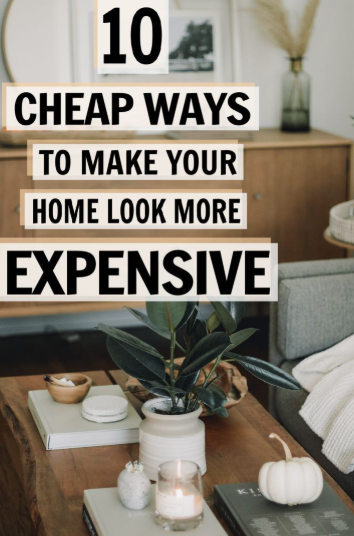 10 Cheap Ways to Make Your Home Look More Expensive A brightly lit, modern living room with a coffee table styled with stacked books, a potted plant, a lit candle, and a decorative white pumpkin, demonstrating cheap ways to make your home look more expensive.