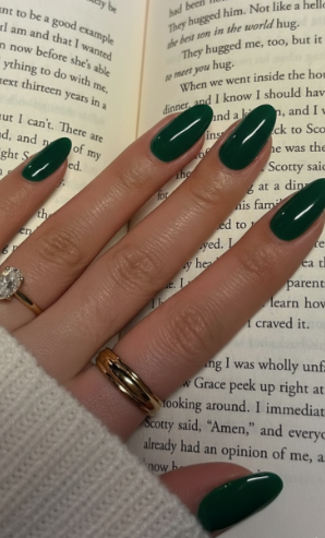 25 Short Fall Nail Ideas for 2026: Chic, Simple & Trendy Designs Short fall nail ideas 2026 showcasing glossy dark green oval nails resting on an open book page.