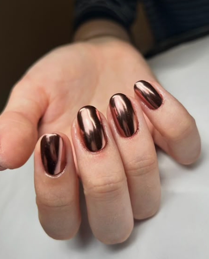 25 Short Fall Nail Ideas for 2026: Chic, Simple & Trendy Designs Short fall nail ideas 2026 showcasing short, rounded nails finished in a high-shine metallic bronze chrome polish.