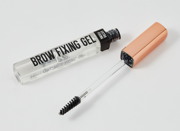 20 Types of Makeup and Their Uses: A Complete Beginner’s Guide Open tube of transparent brow fixing gel with a spoolie applicator brush for types of makeup and their uses.