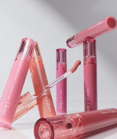 20 Types of Makeup and Their Uses: A Complete Beginner’s Guide Collection of glossy lip tint tubes featuring pink and coral shades with a doe-foot applicator for types of makeup and their uses.