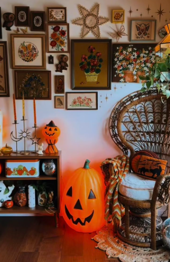 A curated gallery wall featuring framed botanical prints and vintage artwork arranged above a cozy corner, highlighting creative Halloween decor ideas for indoor spaces.