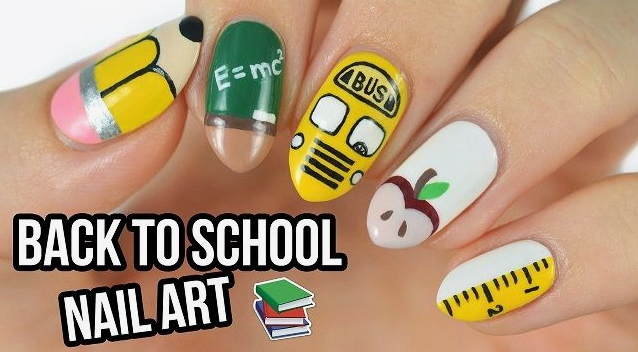 18 Back-to-School Nail Designs for a Fresh Start This School Year Close-up of creative back-to-school nail designs featuring miniature painted school motifs including a yellow pencil, chalkboard with equations, yellow school bus, apple, and ruler.