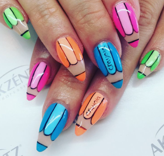 18 Back-to-School Nail Designs for a Fresh Start This School Year Close-up of colorful back-to-school nail designs painted to look like vibrant wax crayons and colored pencils in shades of blue, orange, pink, and green.