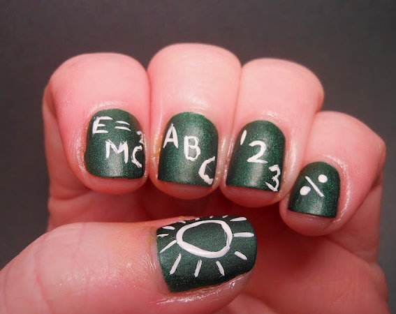 18 Back-to-School Nail Designs for a Fresh Start This School Year Close-up of clever back-to-school nail designs featuring a dark green chalkboard background painted with white chalk-style math and alphabet doodles, including E equals mc squared, ABC, 123, and a division sign.