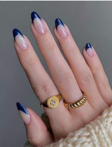 18 Back-to-School Nail Designs for a Fresh Start This School Year Close-up of elegant back-to-school nail designs featuring sleek navy blue French tips on long, almond-shaped neutral nails.