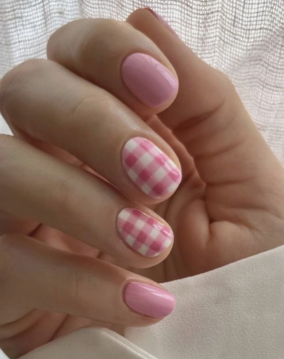18 Back-to-School Nail Designs for a Fresh Start This School Year Close-up of sweet back-to-school nail designs featuring short, rounded nails in solid light pink alternating with charming pink and white gingham plaid accent nails.