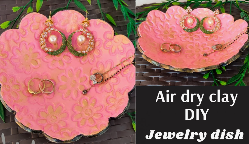 A pink and gold scalloped trinket tray showcasing creative air dry clay ideas holding jewelry items like earrings, rings, and a necklace.