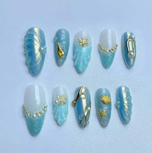15 Stunning 3D Nail Designs to Try This Season Stunning 3D nail designs featuring an ocean-themed press-on set with metallic shells, tiny starfish, and glossy blue gradients.