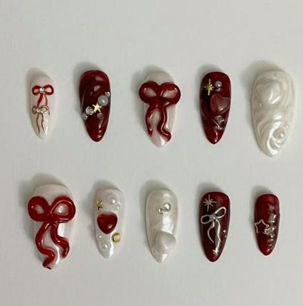 15 Stunning 3D Nail Designs to Try This Season Chic 3D nail designs featuring a press-on set in deep red and pearl white tones with sculpted bows, hearts, stars, and pearls.