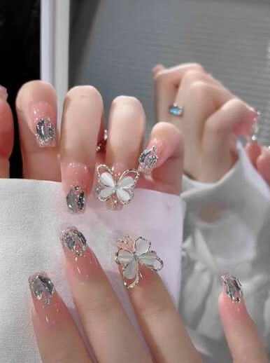 15 Stunning 3D Nail Designs to Try This Season Glamorous 3D nail designs featuring stunning cat-eye stone butterflies and sparkling silver charms on a glossy pink base.