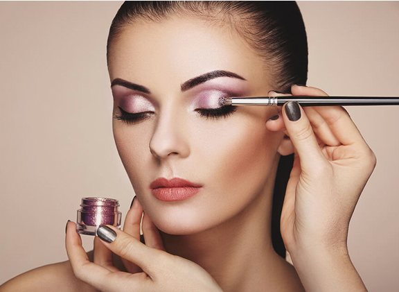 Makeup artist applying shimmering pink eyeshadow with a brush, capturing the essence of Fall 2026 Beauty Trends.
