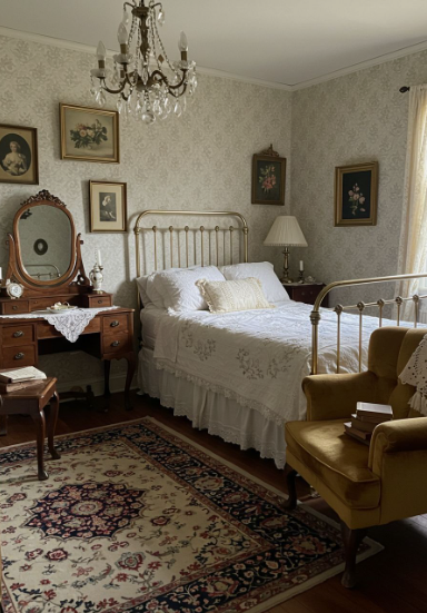 Small Living Room Decor Ideas on a Budget: 25 Stylish Ways to Make It Look Expensive Vintage bedroom featuring small living room decor ideas on a budget with an antique metal frame bed, a wooden vanity with a mirror, a mustard yellow armchair, a crystal chandelier, and patterned wallpaper.