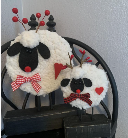 30 DIY Crafts Using Things You Already Have at Home Two adorable handmade sheep figures crafted from fluffy white textured yarn, felt, and wooden blocks, decorated with red bows and berry antlers for DIY crafts using things you have at home.