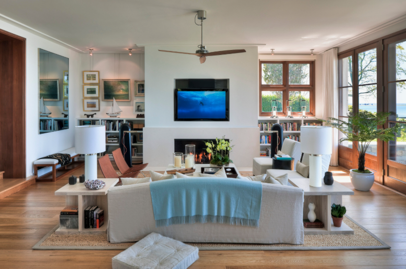 How to Make a Boring Room Look Better: 15 Simple Fixes Modern living room featuring a cozy fireplace, built-in shelving, and a neutral sofa draped with a soft blue throw blanket, illustrating how to make a boring room look better.