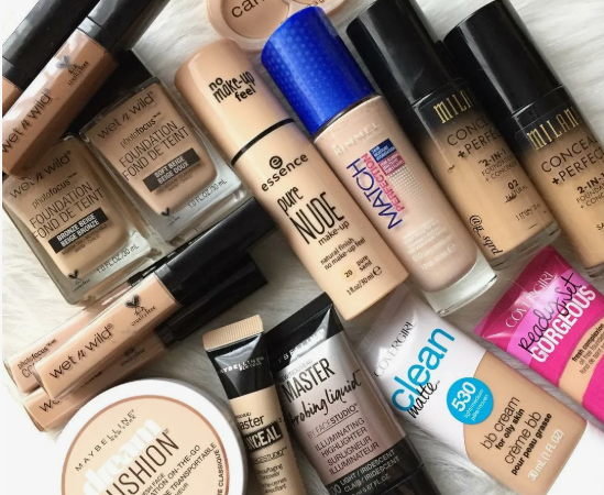 Best Drugstore Beauty Products Under $20 That Are Actually Worth It Flat lay arrangement of various affordable foundation, concealer, and BB cream tubes from brands like Wet n Wild, Milani, and CoverGirl, highlighting best drugstore beauty products under $20.