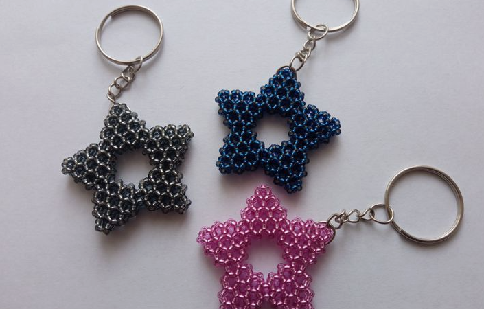 A trio of handmade beaded star keychains in silver-black, dark blue, and pink, showcased as a quick craft project under the keyphrase one hour crafts.