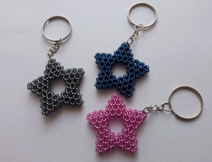 A trio of handmade beaded star keychains in silver-black, dark blue, and pink, showcased as a quick craft project under the keyphrase one hour crafts.