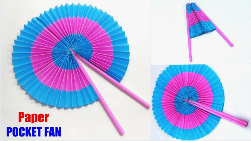 A circular, pleated accordion fan featuring alternating concentric rings of blue and pink color, attached to pink paper handles so it can open and fold closed.