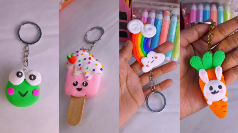 A collage of four handmade air dry clay crafts styled as cute keychains, featuring a green frog face, a smiling pink popsicle with sprinkles, a rainbow with clouds, and a white bunny peeking out of an orange carrot.   