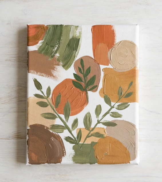 Modern abstract canvas painting featuring textured earthy color blocks and painted green botanical branches, showing crafts you can finish in one afternoon.