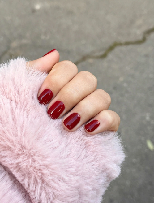 Glossy classic red manicure on neat squoval shapes showcasing chic nail art ideas for short natural nails.