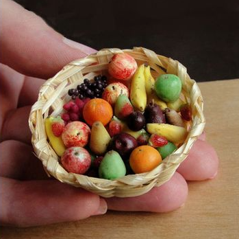 A tiny woven basket held in a person's hand, filled with miniature sculpted fruits showcasing delicate air dry clay ideas.