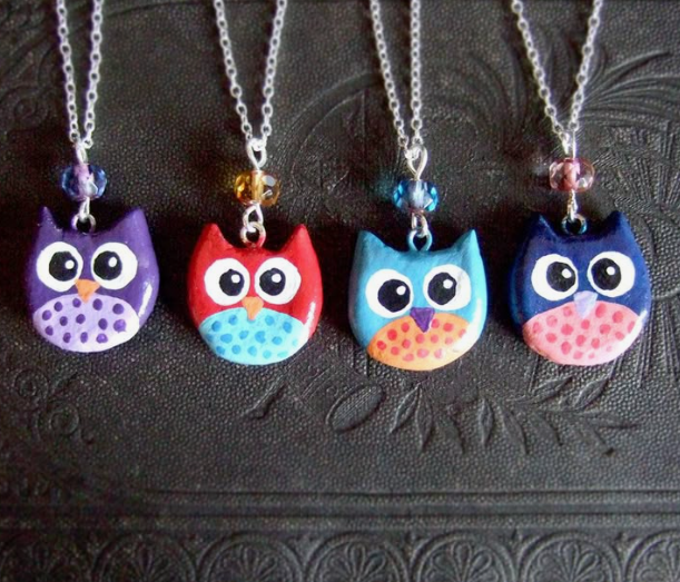 Four colorful handmade owl necklaces displaying whimsical air dry clay ideas, featuring painted ceramic-style charms on silver chains.