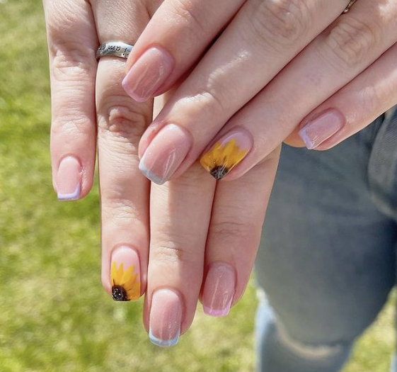 24 Sunflower Nail Ideas for a Bright, Cheerful Manicure sunflower nail ideas featuring light blue French tips on nude nails, highlighted with accent nails showcasing detailed yellow and brown sunflowers.
