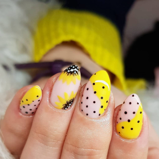 24 Sunflower Nail Ideas for a Bright, Cheerful Manicure sunflower nail ideas featuring almond-shaped nails with a creative mix of polka-dot color blocking in yellow and nude, accented with hand-painted yellow and black sunflowers.