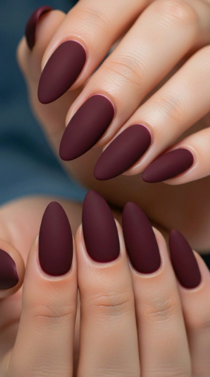Chic almond-shaped burgundy nail designs featuring a smooth, velvety matte finish in a deep dark red shade
