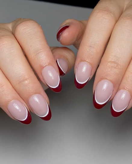 Creative burgundy nail designs featuring elegant double-line French tips with a thick burgundy base and thin white accent lines on a nude manicure.