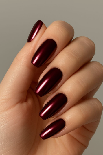 Striking metallic burgundy nail designs featuring long square-shaped nails with a reflective chrome or foiled dark red finish.