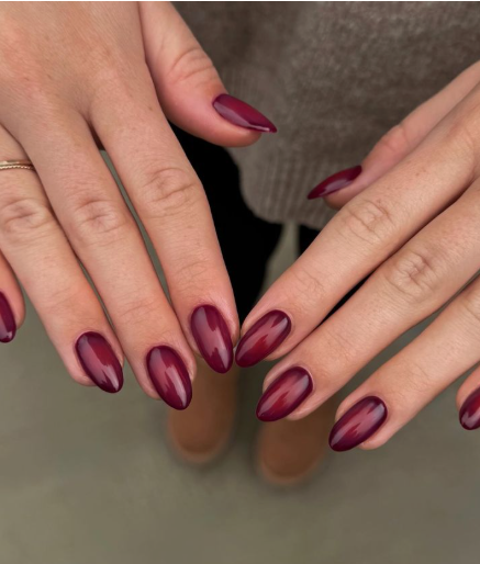 Glossy oval-shaped burgundy nail designs featuring a rich, luminous dark red gel finish with a subtle depth dimension.